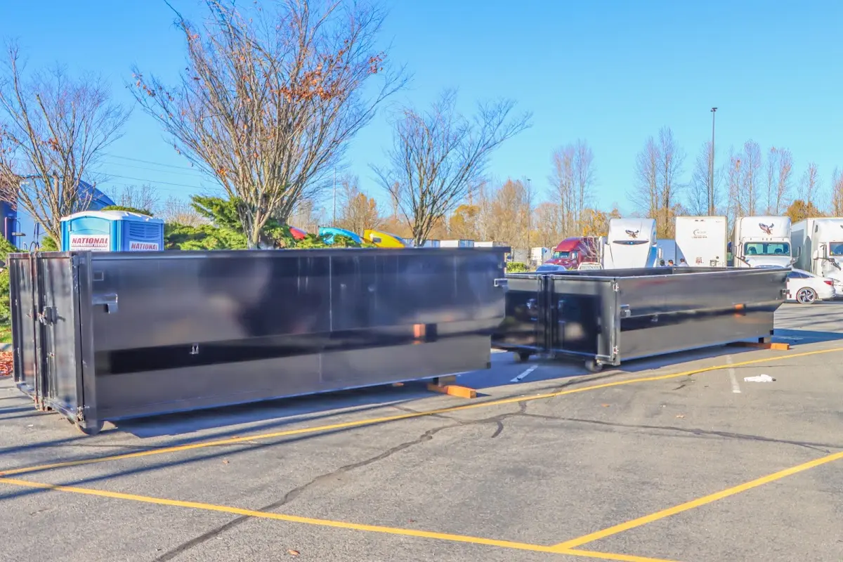 Professional dumpster rental service with roll-off container on residential driveway in Boone